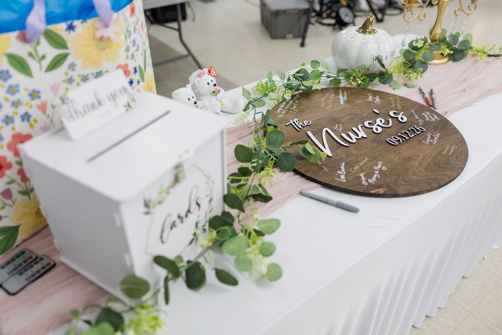 Rustic wedding guest book table with wooden sign, greenery, white card box, and floral decorations.