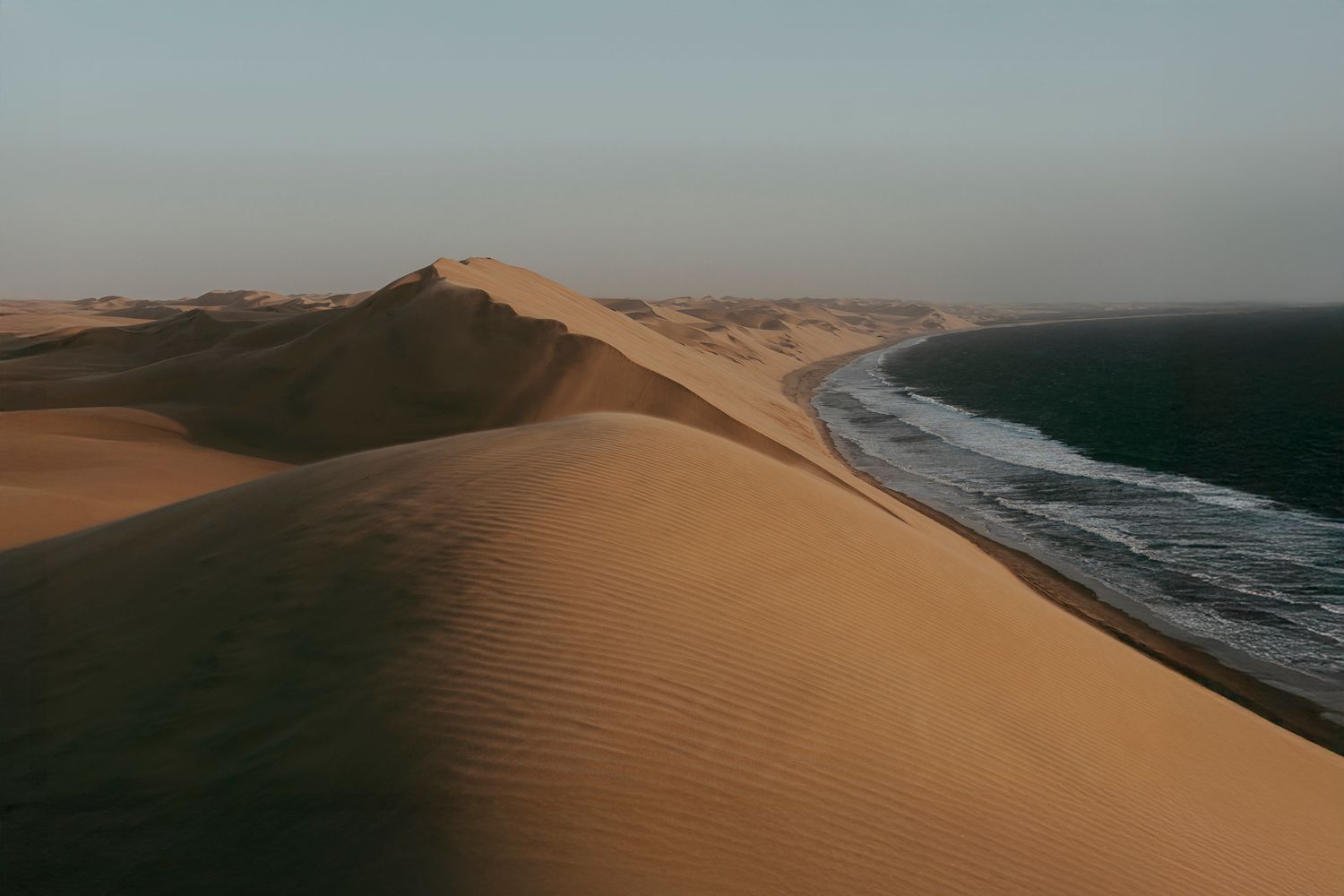 Sandwich Harbour dunes meeting the Atlantic Ocean in Namibia