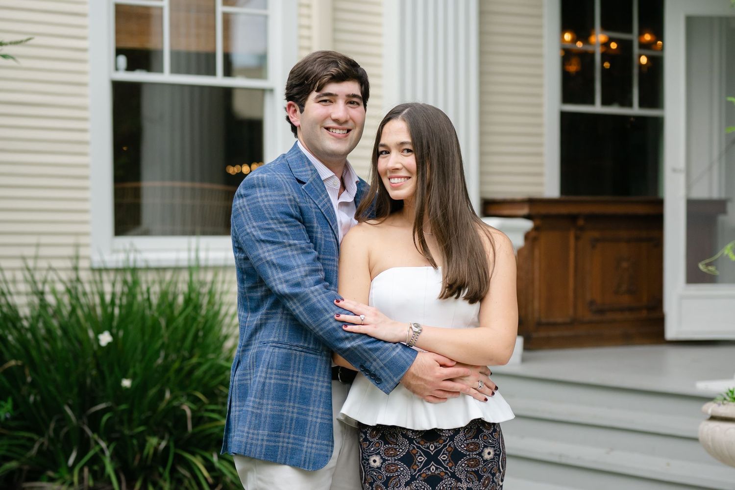 Newly engaged couple posing for a picture in front of The Marlene hotel.