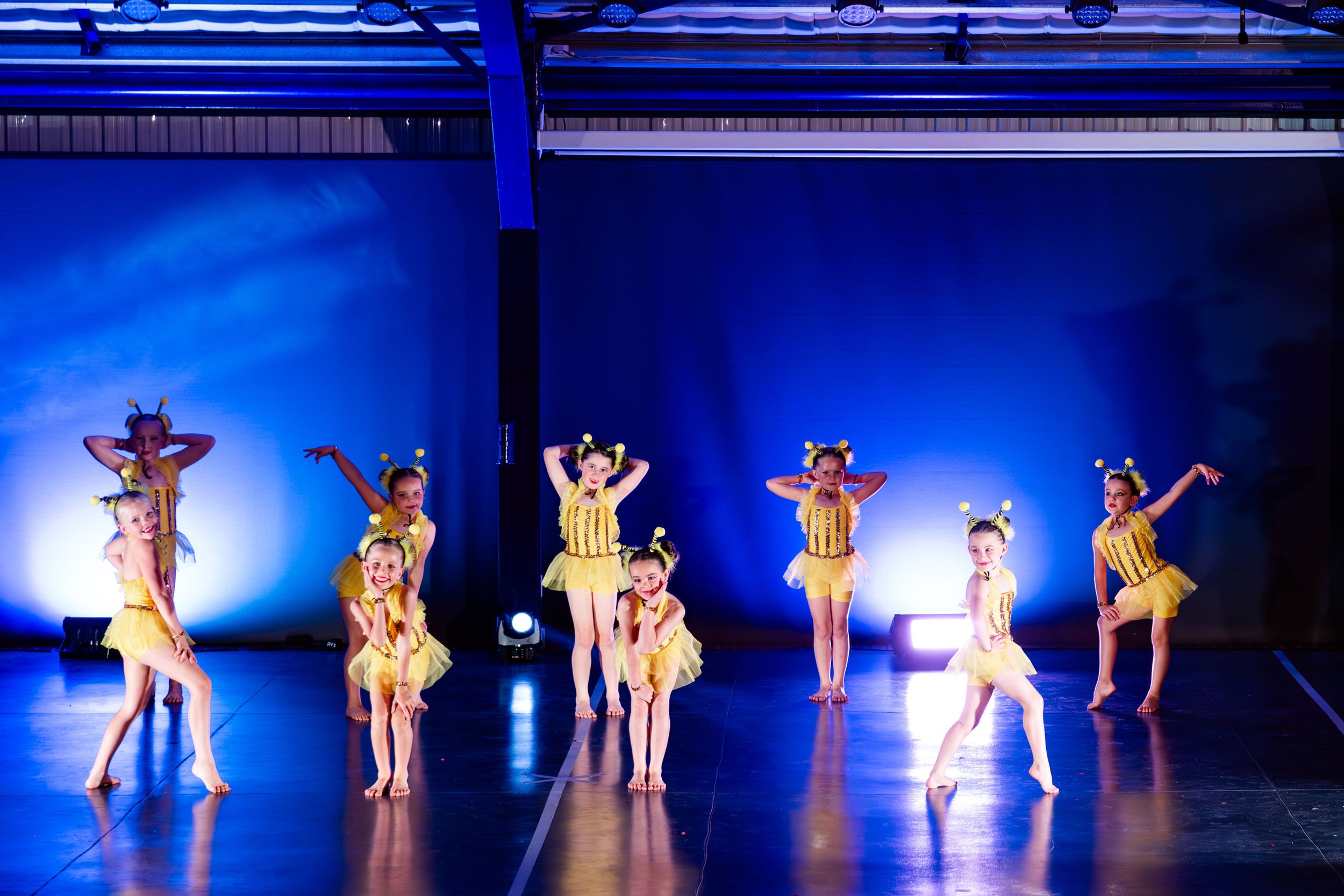 A large group of dancers performing together during a live dance concert.
