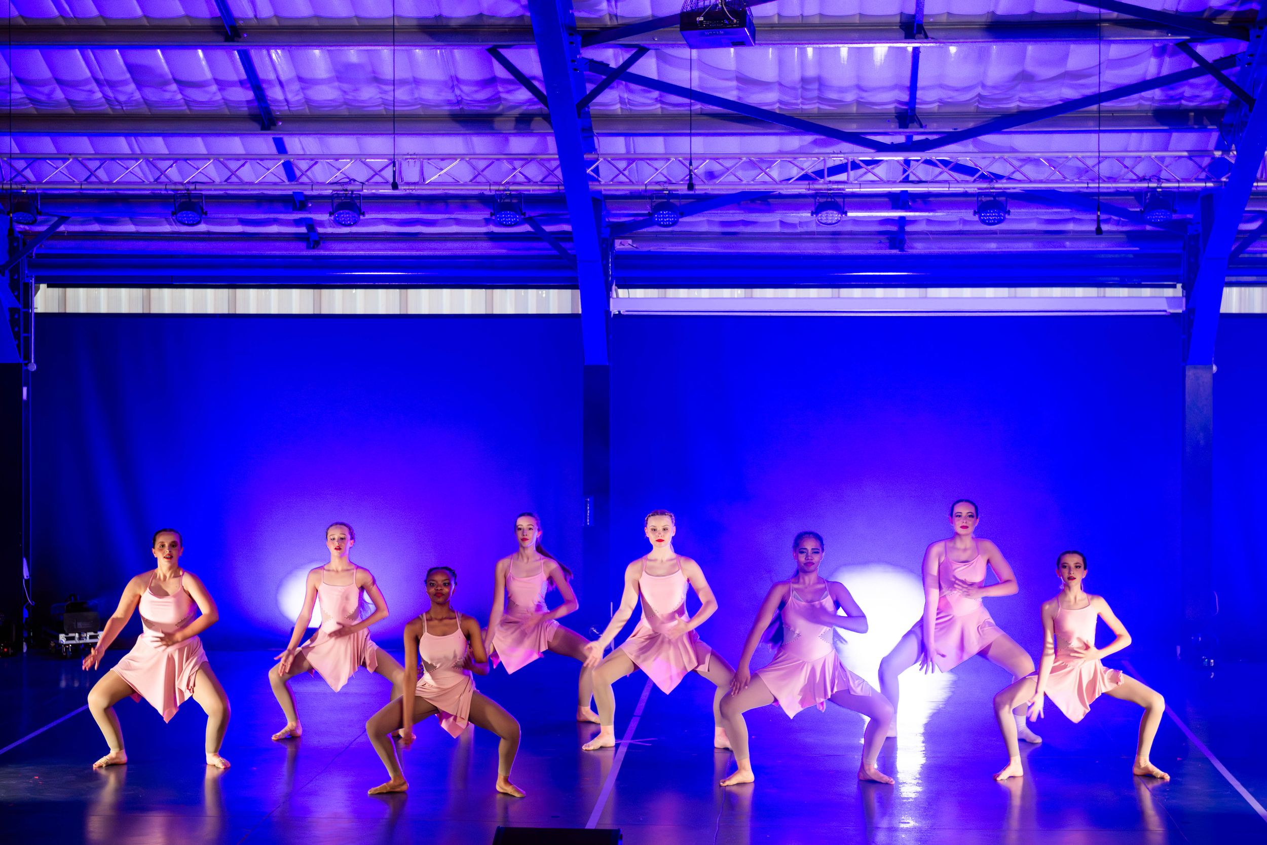 Dance group performing an energetic choreographed routine during a live concert.