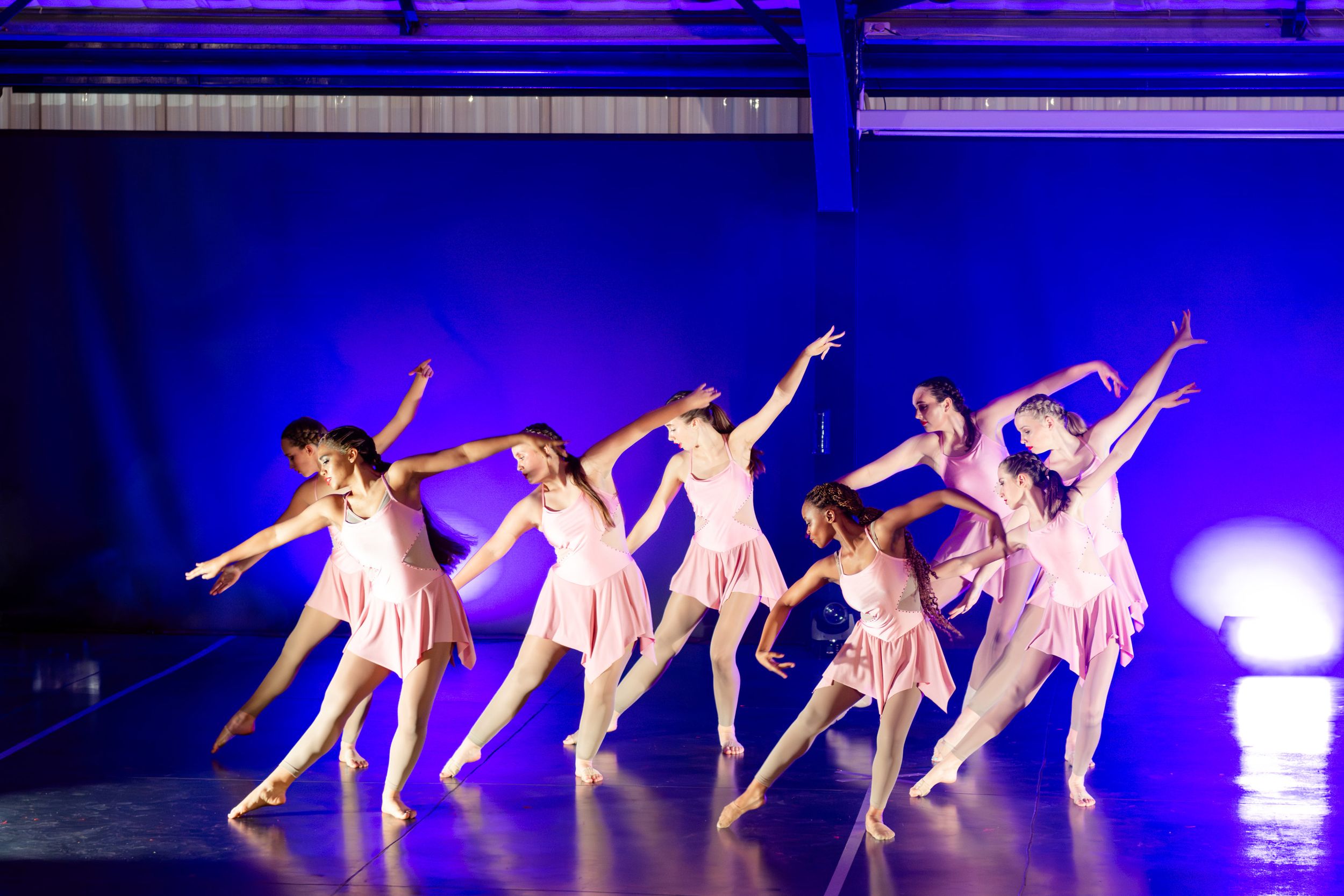 An image of contemporary dancers captured mid-performance during a colourful stage production.