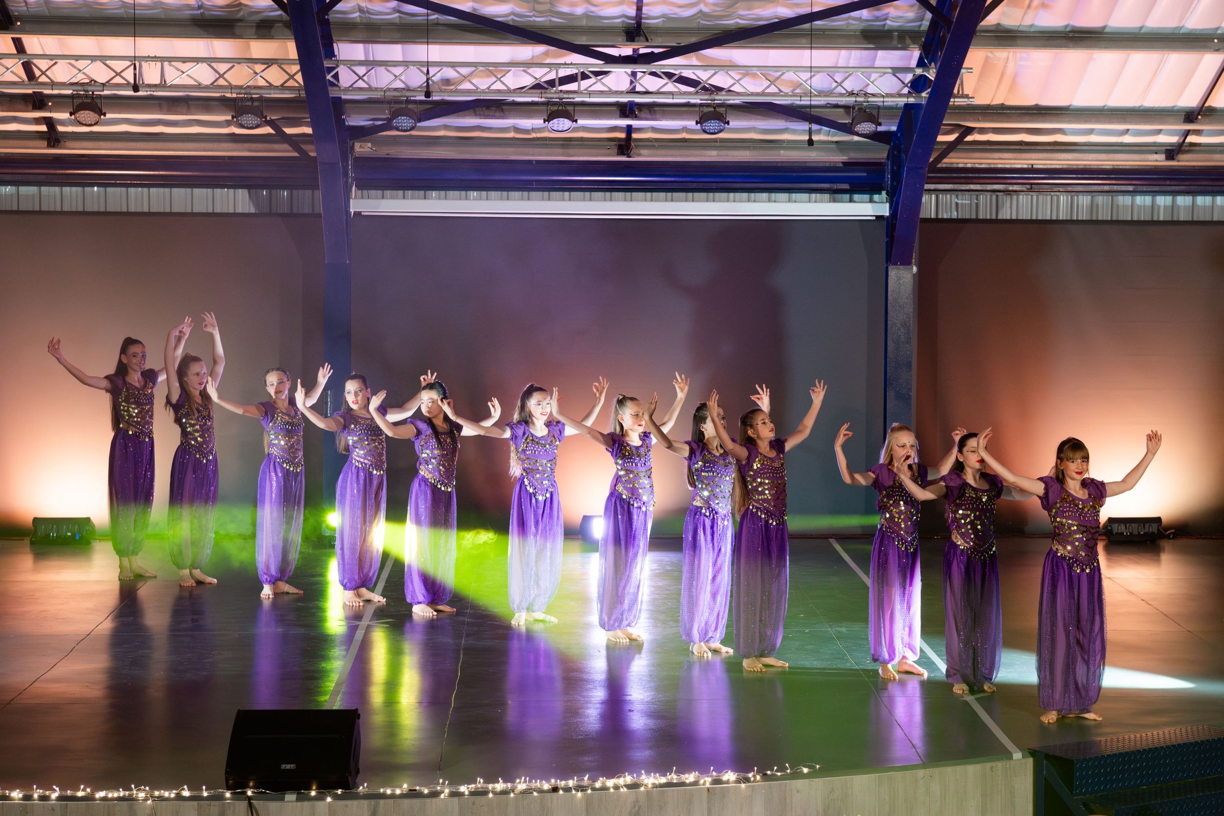 An image of a group of dancers, dancing on stage.