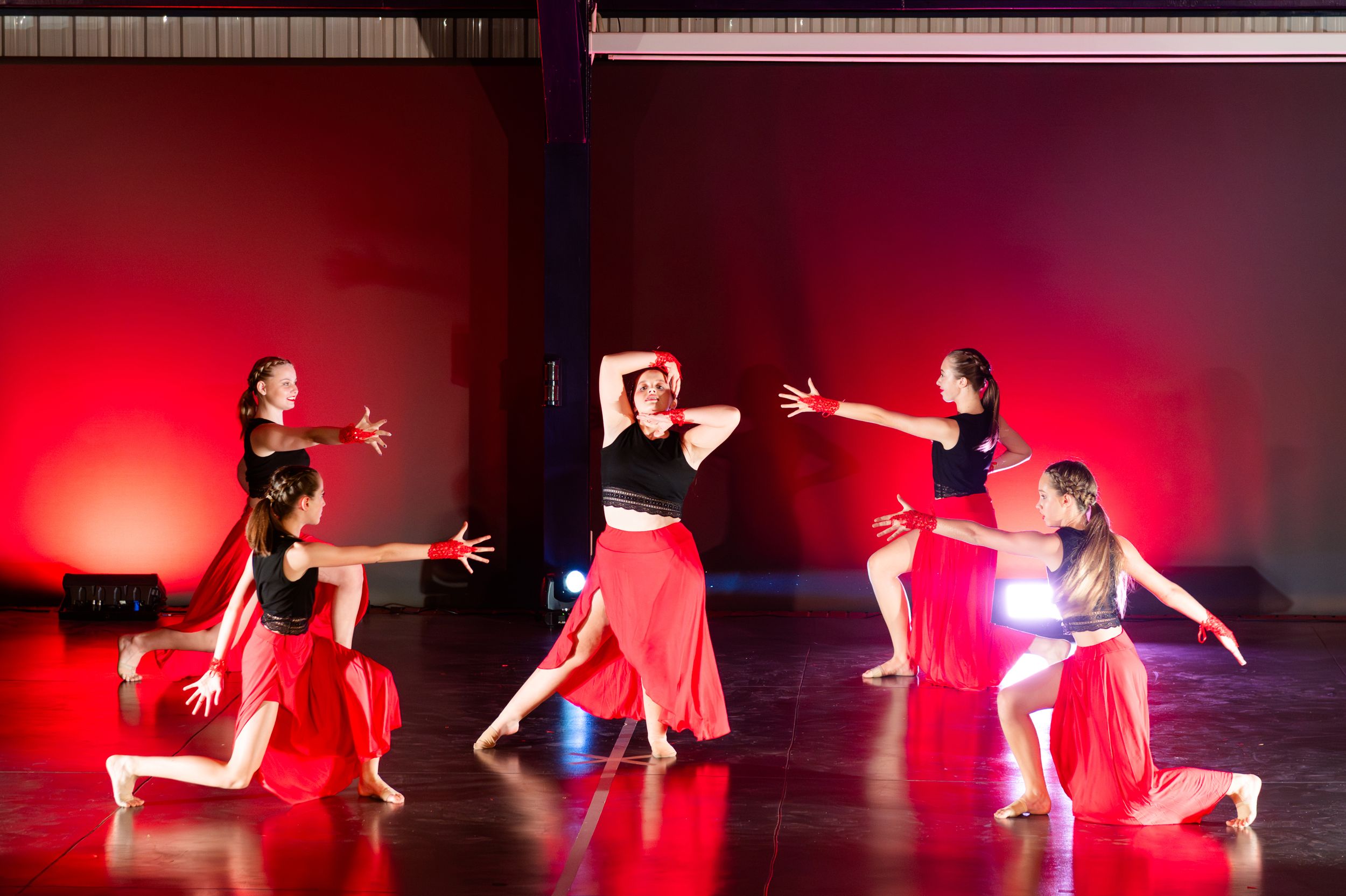 An image of young dancers performing a choreographed routine during a colourful dance concert.