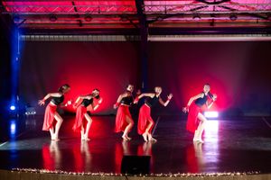 Group dance performance captured in motion during a colourful live stage production.