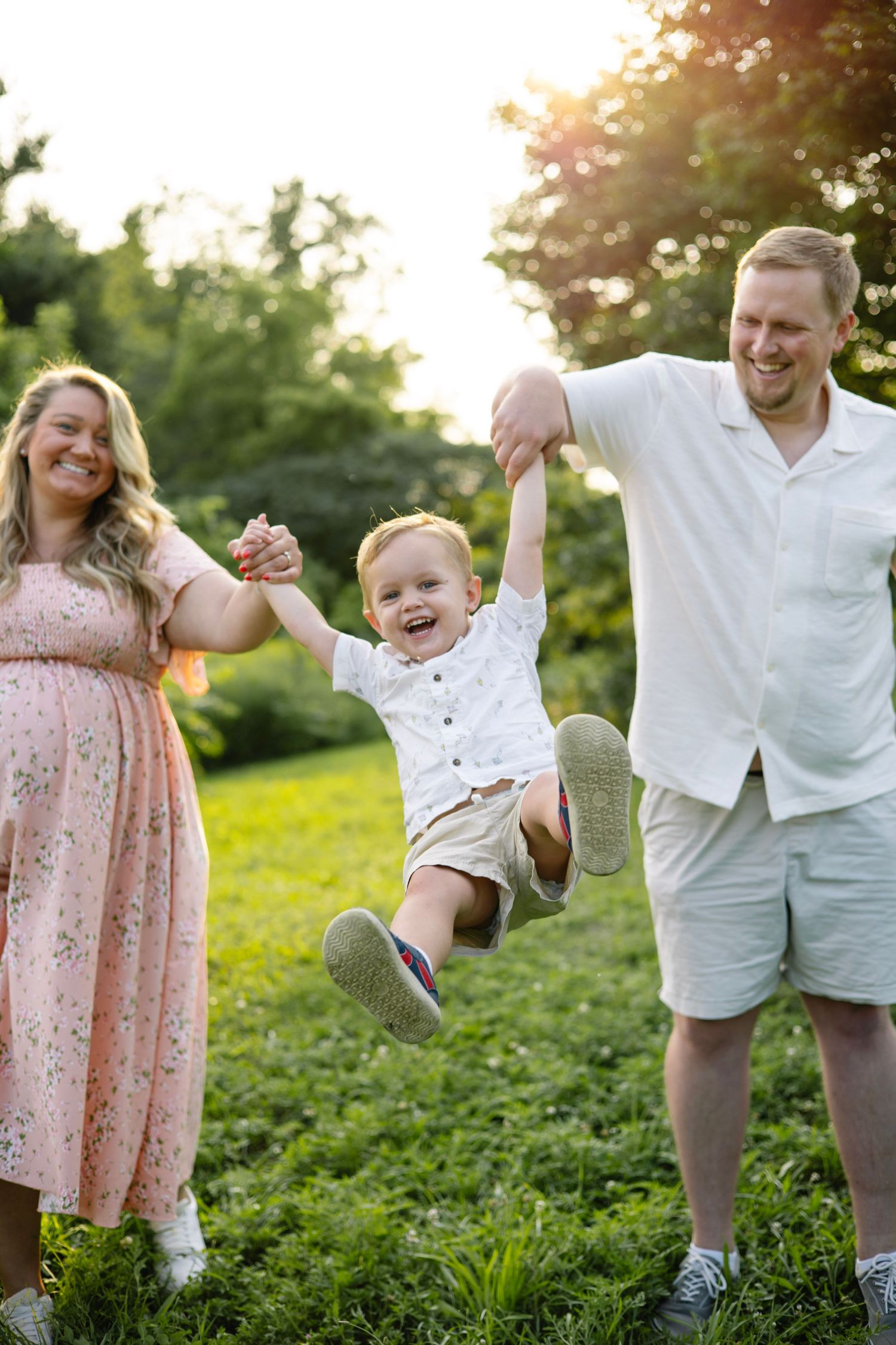 Candid moment of parents having fun with their toddler during a golden hour outdoor photo session