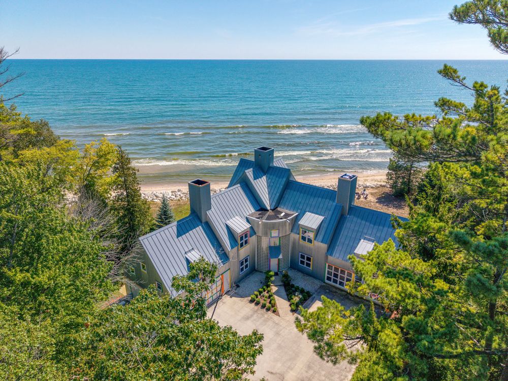 Drone photo of the Crayola House roofline above the tree line with Lake Michigan beyond