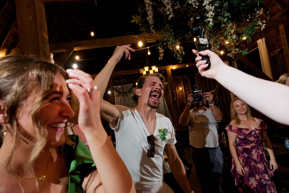 The bride holds a Luna Ultra action cam used to film custom bachelor and bachelorette party footage for her wedding.