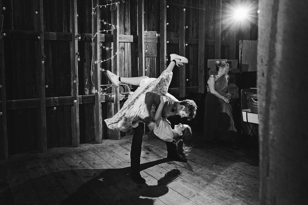 High-energy wedding photography of an epic reception dance floor dip at The Centennial Barn in Wayland, MI.