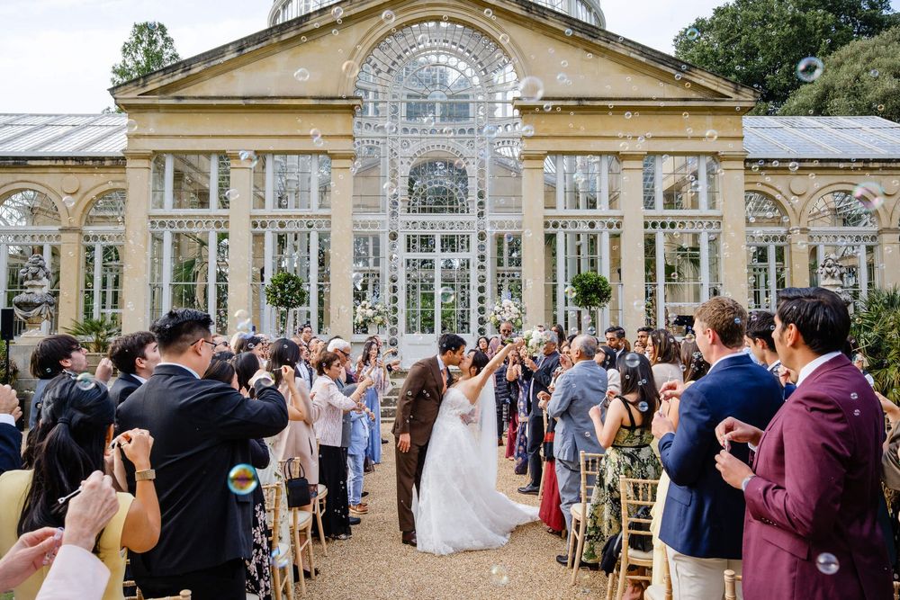 bride and groom walking back down the aisle with bubbles