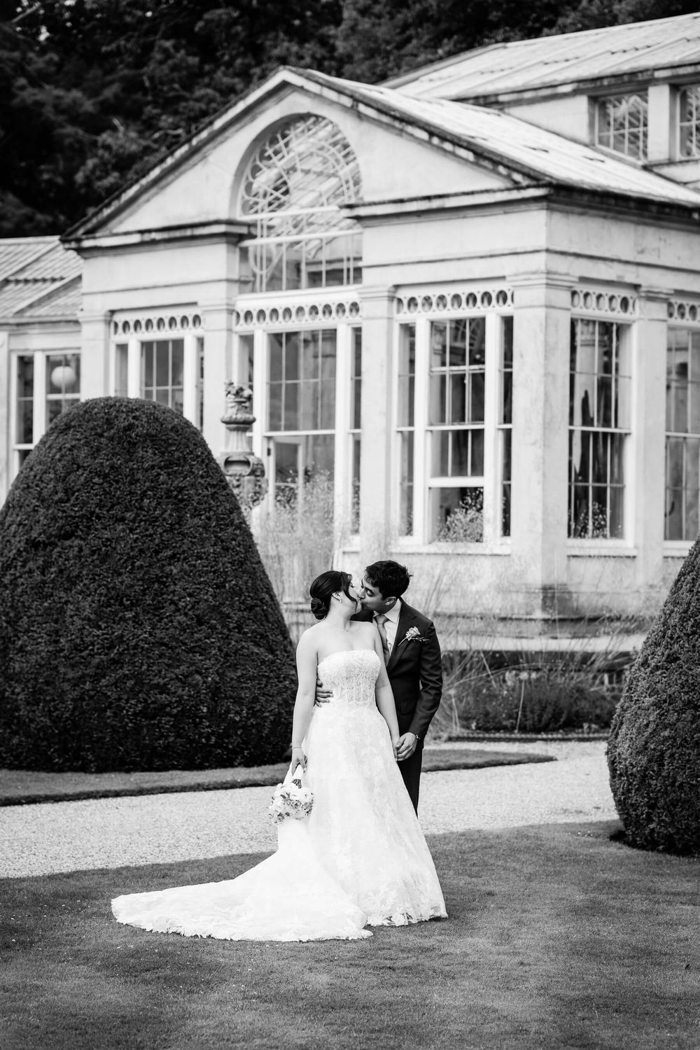bride and groom kiss on the grounds of Syon park