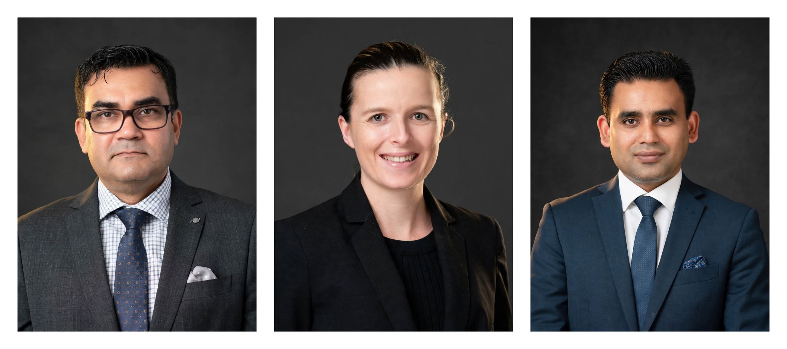 Three professional business executives in formal attire posing for corporate headshots against a dark gray background.
