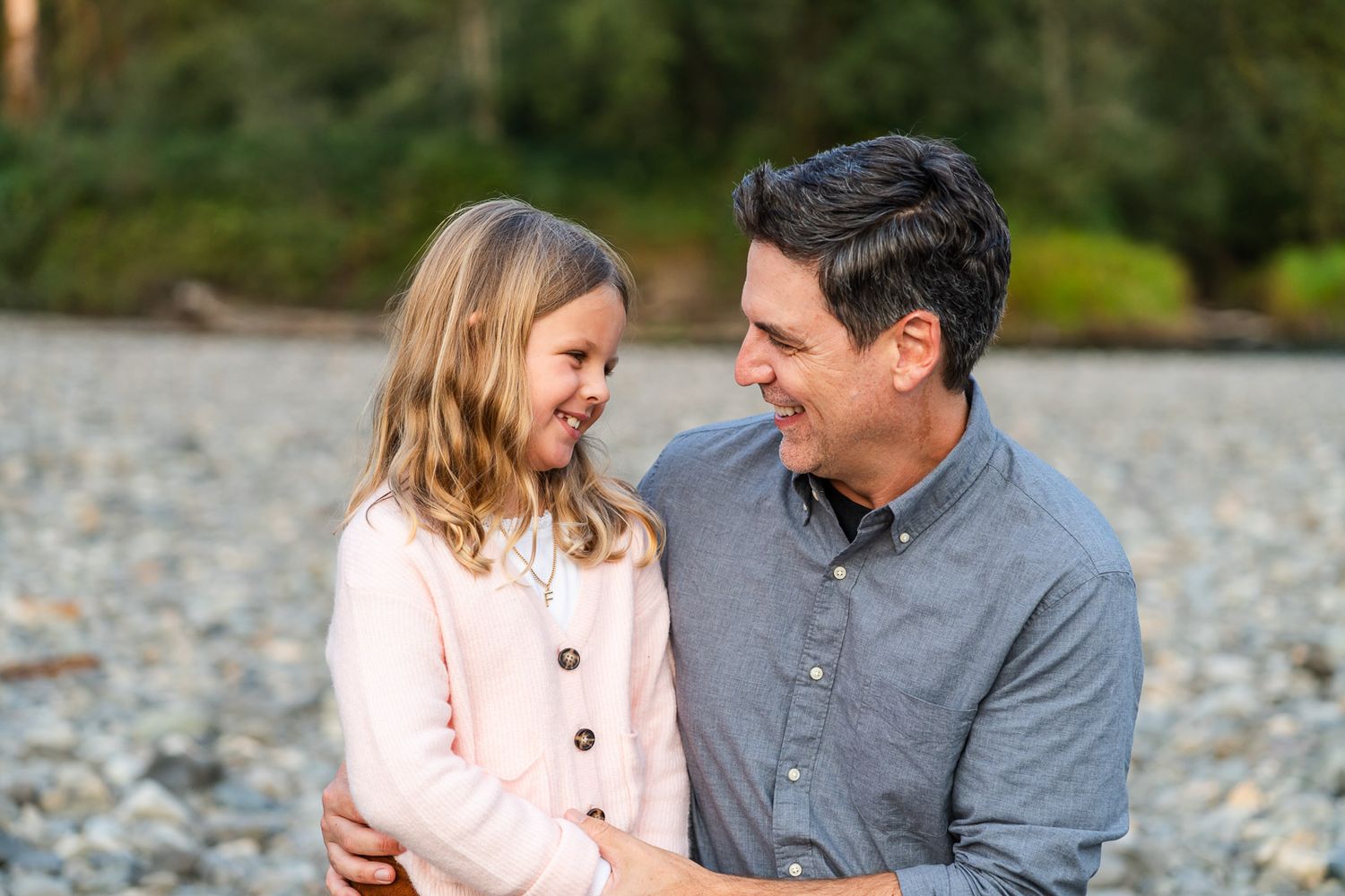 Father and daughter tickling each other and smiling.