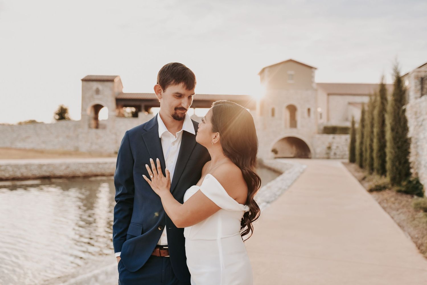 Golden hour engagement portrait with warm sunlight glowing behind Chapel at Palacios