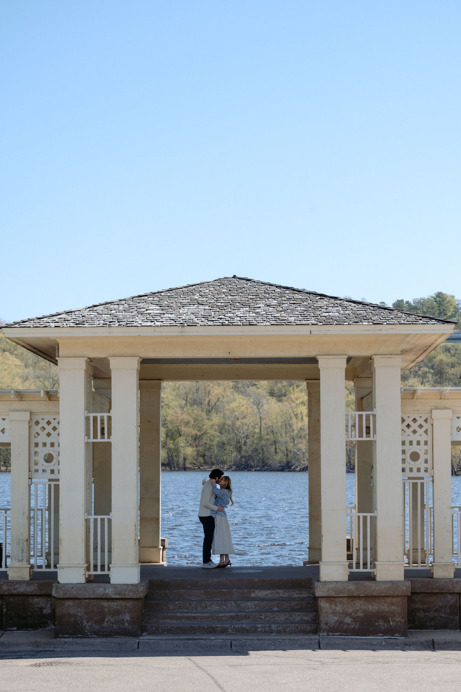 A newly engaged couple embraces after their serene proposal on the St. Croix River in downtown Stillwater, MN.