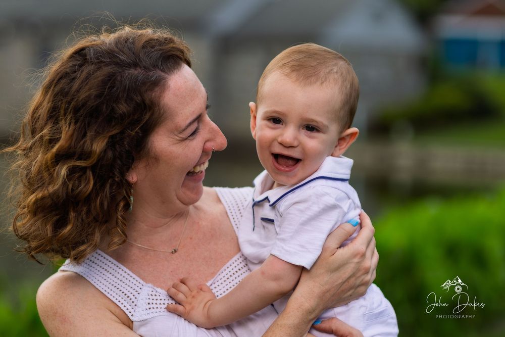 A joyful moment shared between parent and baby during outdoor family photoshoot.