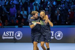 Tennis players embrace in celebration after a match point on the professional tour court.