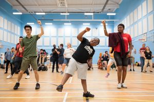 Students exercising in a bright blue gymnasium during fitness class.