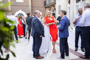 Guests mingling at an outdoor social event wearing business attire.