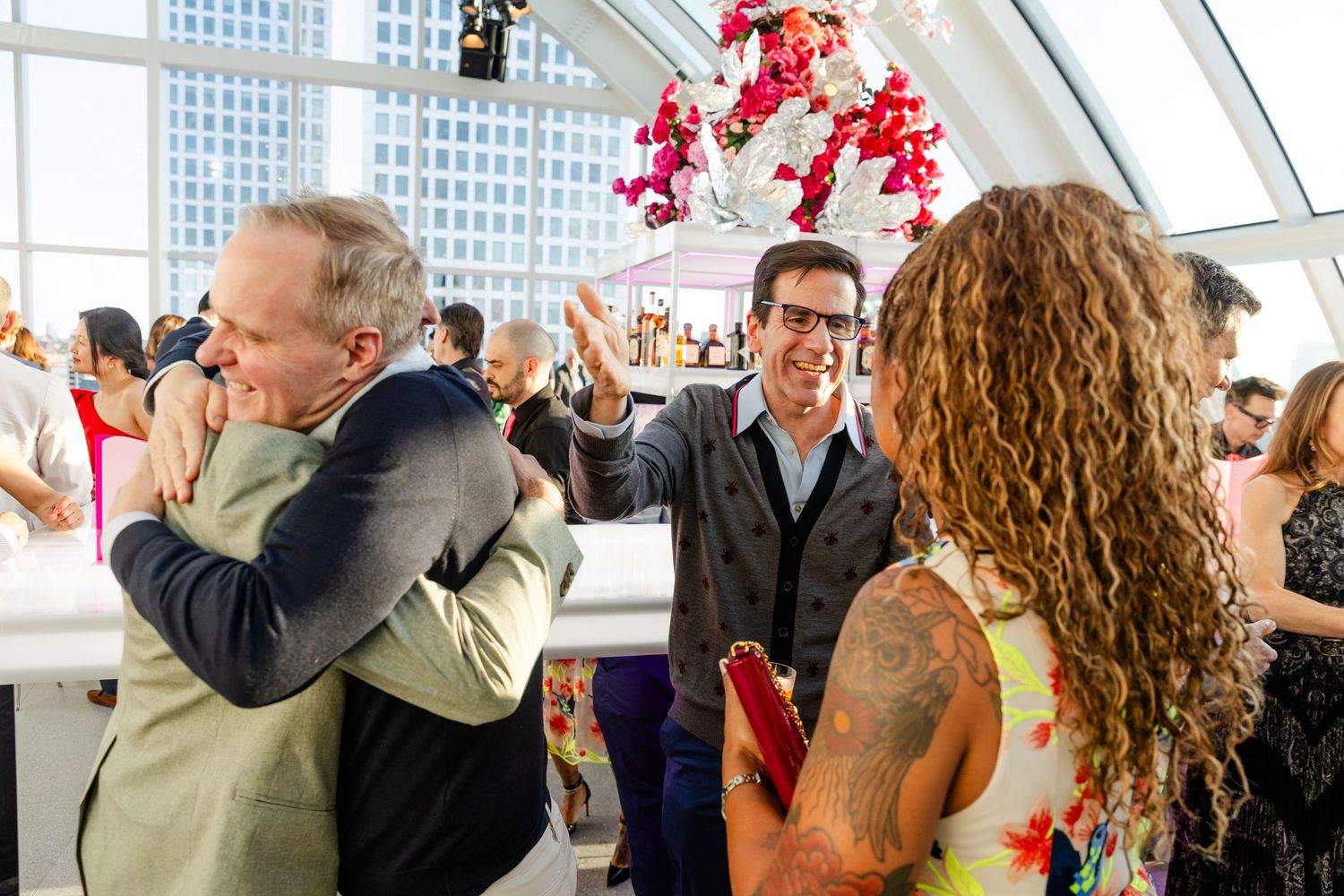 People celebrating in a modern venue with large windows and natural lighting.