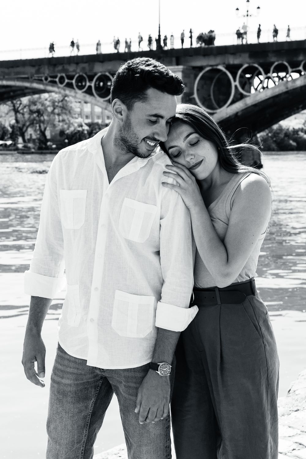 A couple shares an intimate moment together in a series of black and white vintage-style photographs by the water.