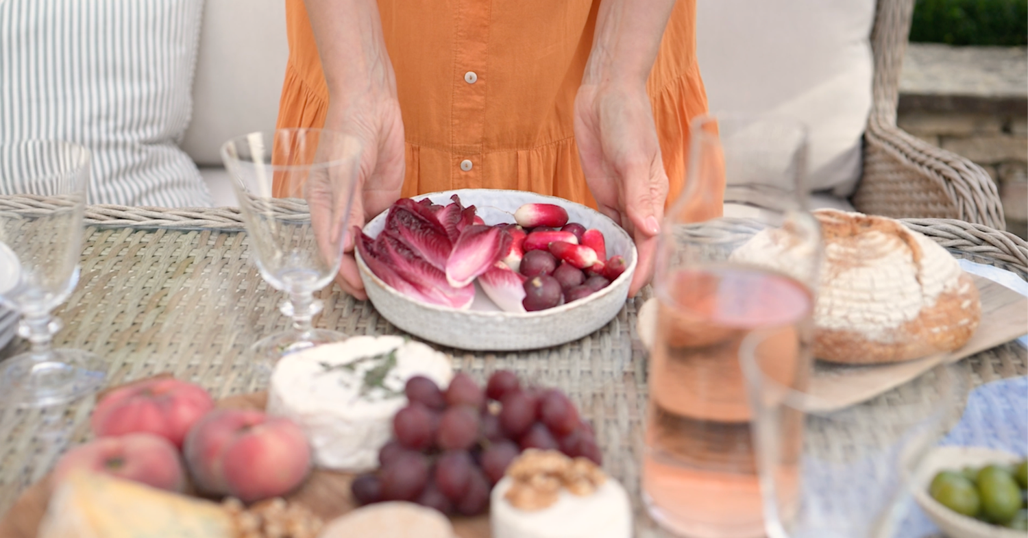 Elegant table setting with wine glasses and fresh fruit for outdoor dining.