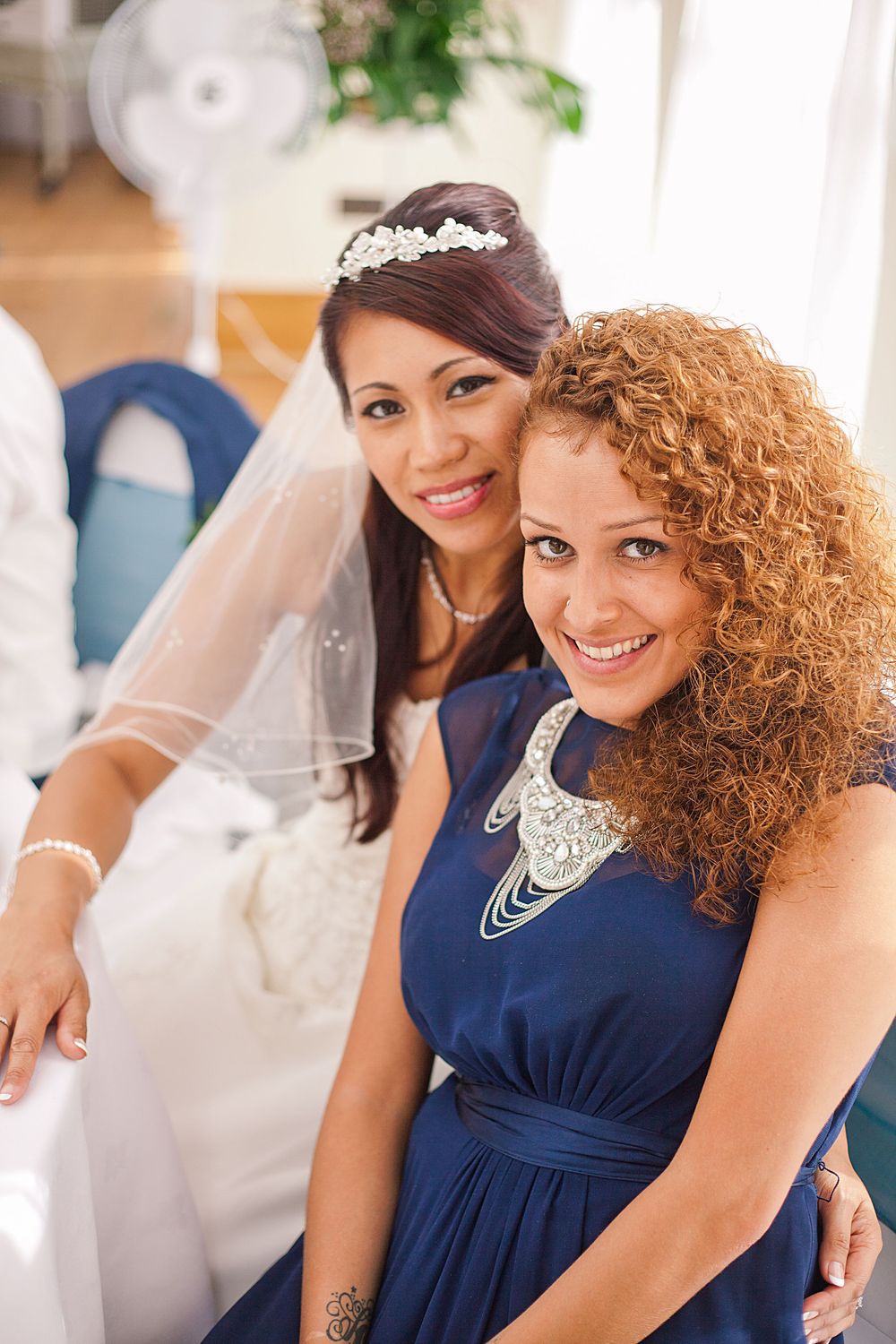 Bridesmaids wearing elegant navy blue dresses pose together at a wedding celebration.