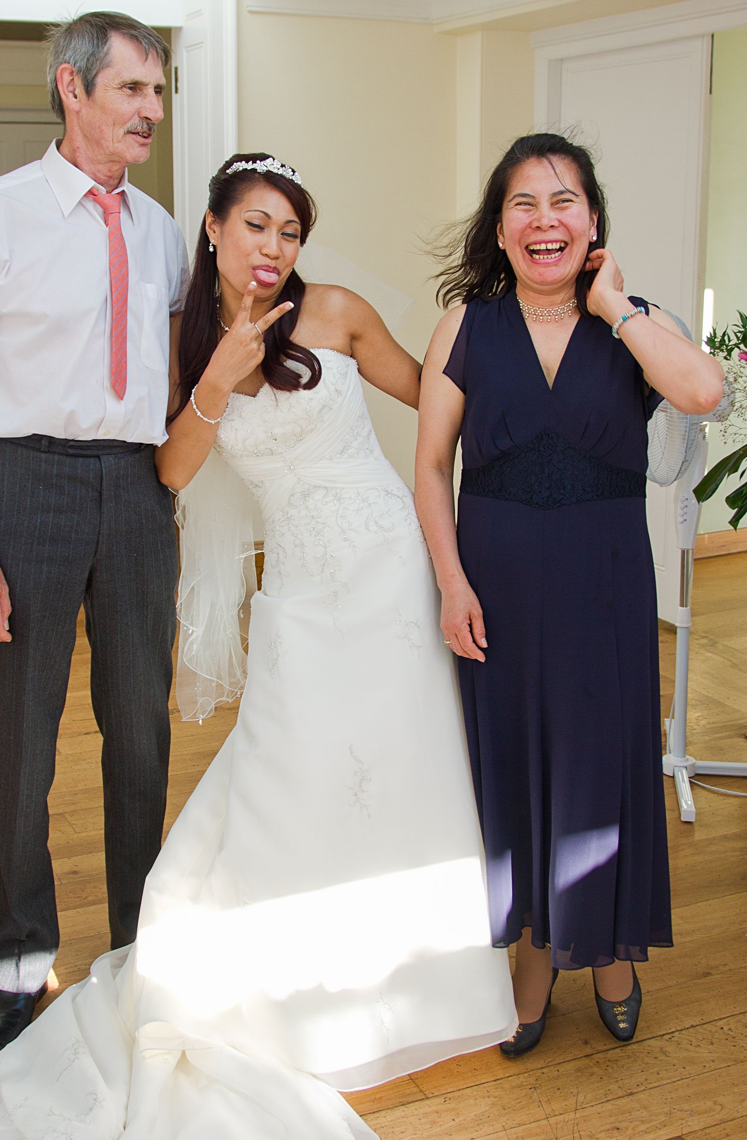A sequence of wedding photos showing candid moments of a bride in a white dress interacting with guests at an indoor venue.