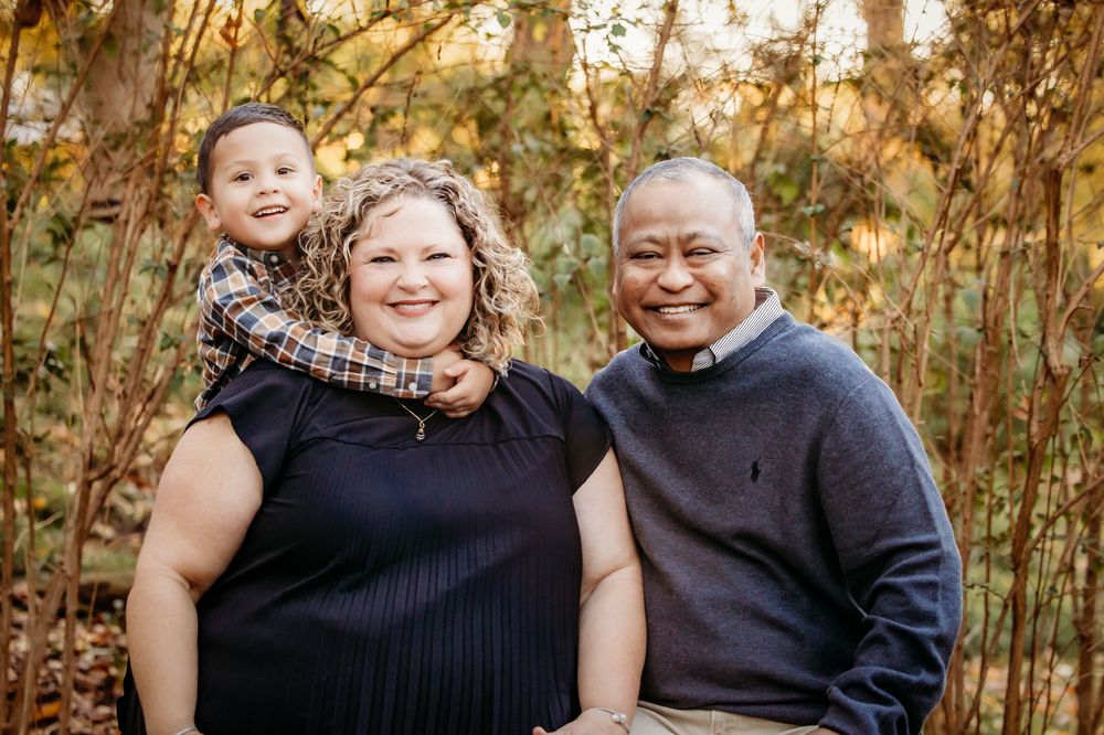 A group of family portraits taken outdoors with autumn foliage and warm lighting in the background.