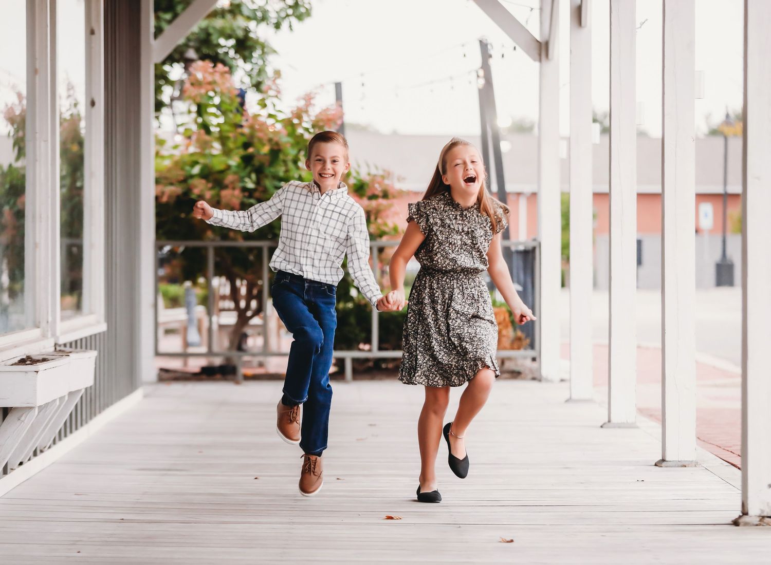 Children running and playing together along a covered outdoor walkway with white columns.
Best child's photographer in Illinois