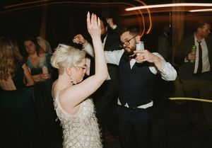 Wedding reception dance floor with guests celebrating in formal attire.