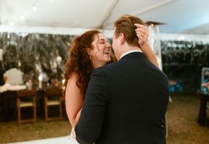Wedding celebration under white tent with dancing couples.