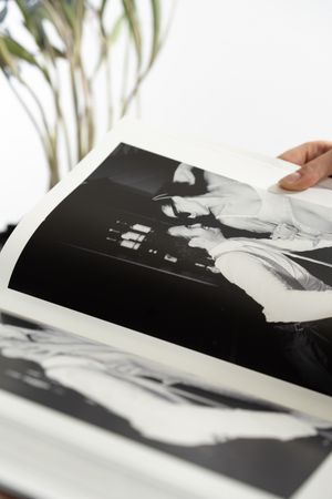 A close-up view of black and white photographs being arranged on a white surface.