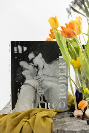 Artistic composition featuring vintage black and white photographs with bright orange tulips against a light background.