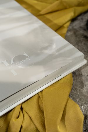 White plastic packaging material rests against yellow fabric on a textured gray surface.