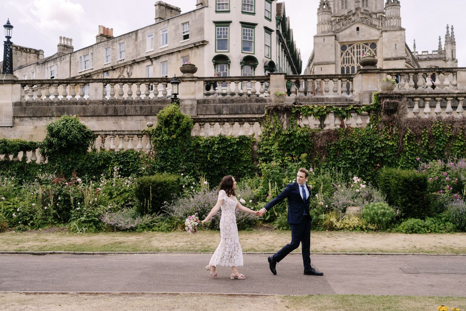 Wedding couple walking through Parade Gardens in Bath city centre after Guildhall ceremony