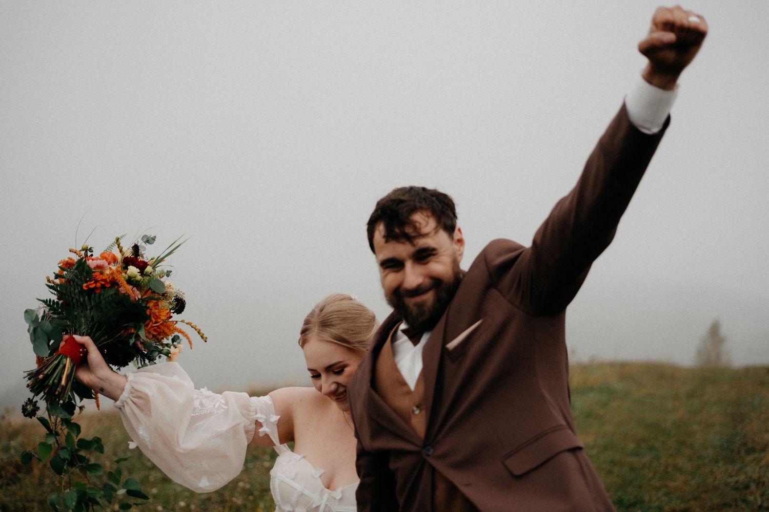 Joyful wedding celebration moments captured in an outdoor setting with dramatic skies.