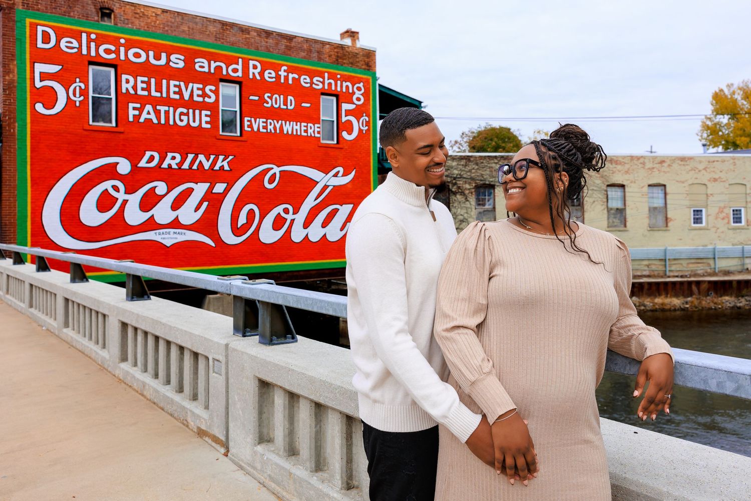 A vintage Coca-Cola advertisement banner with red and white colors displayed outdoors.