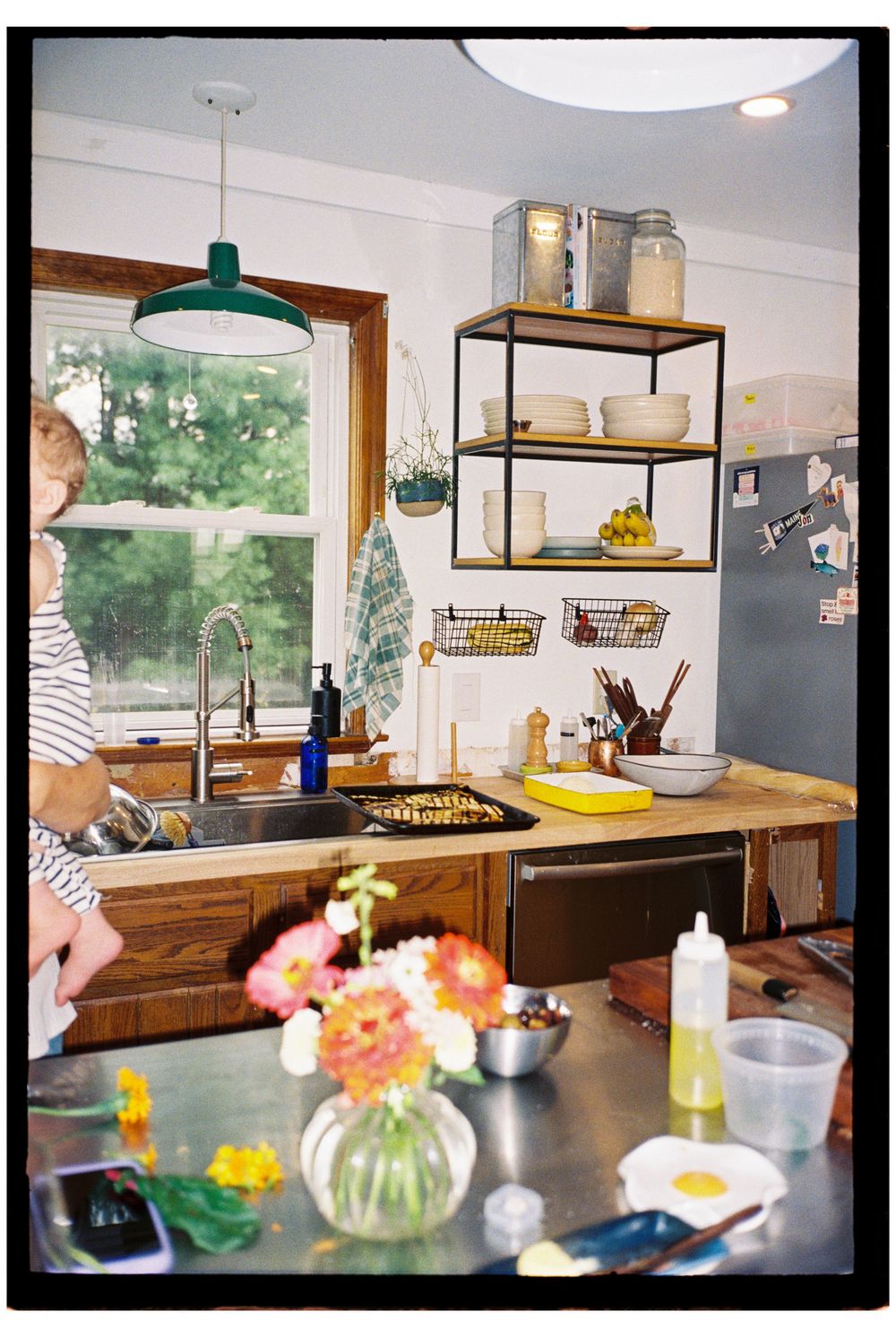 Interior flash kitchen scene highlighting the flowers in the foreground, the garden grown eggplant roasted for dinner at home on film.