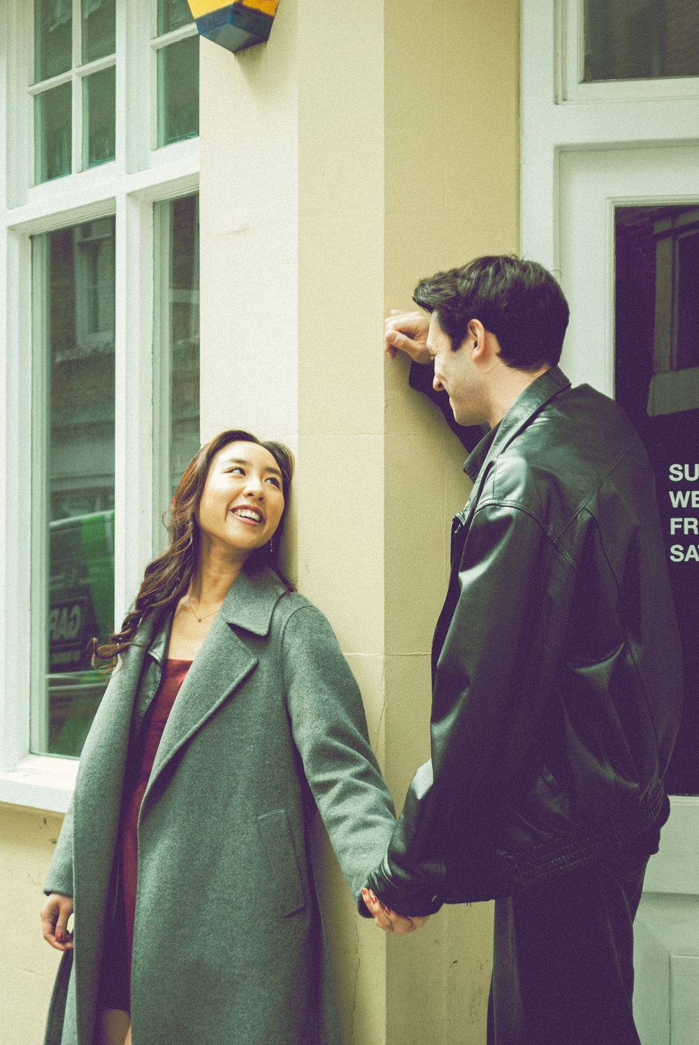 London engagement photography featuring a couple holding hands in an elegant city setting.