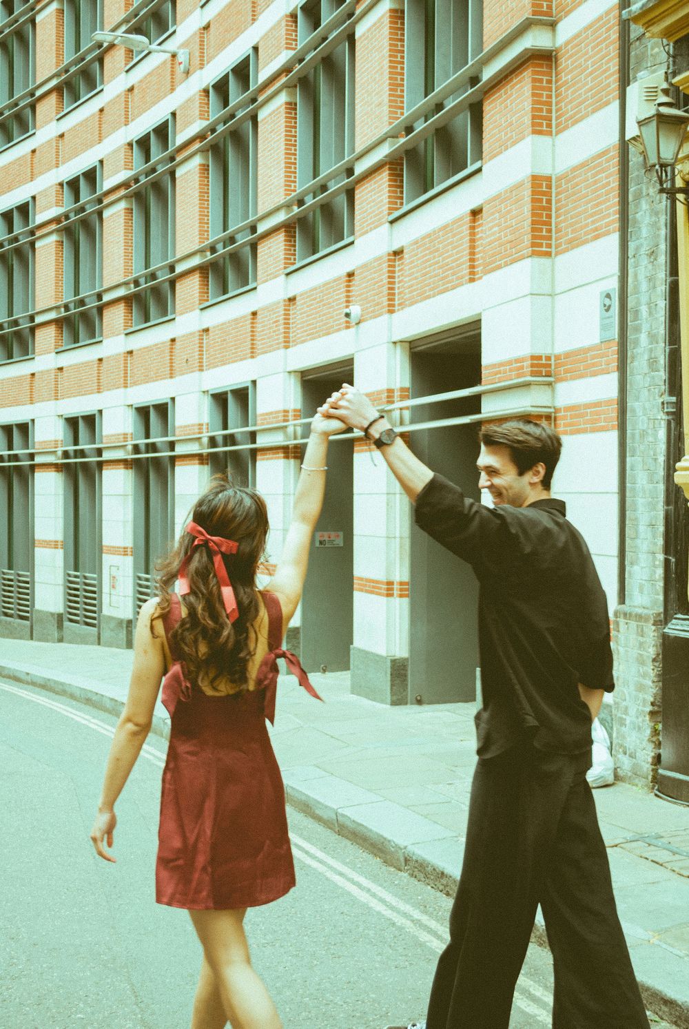 London engagement session showing a couple walking through classic city architecture.