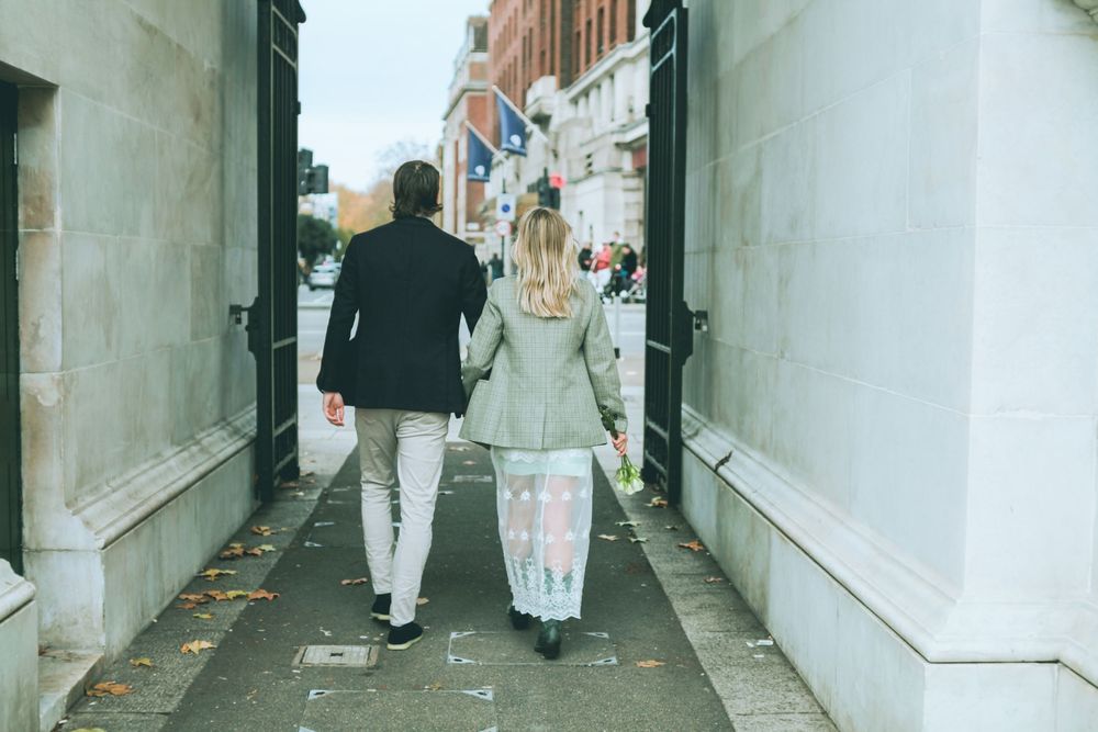 London engagement photography showing a couple walking together through a classic city passage. Marble Arch.