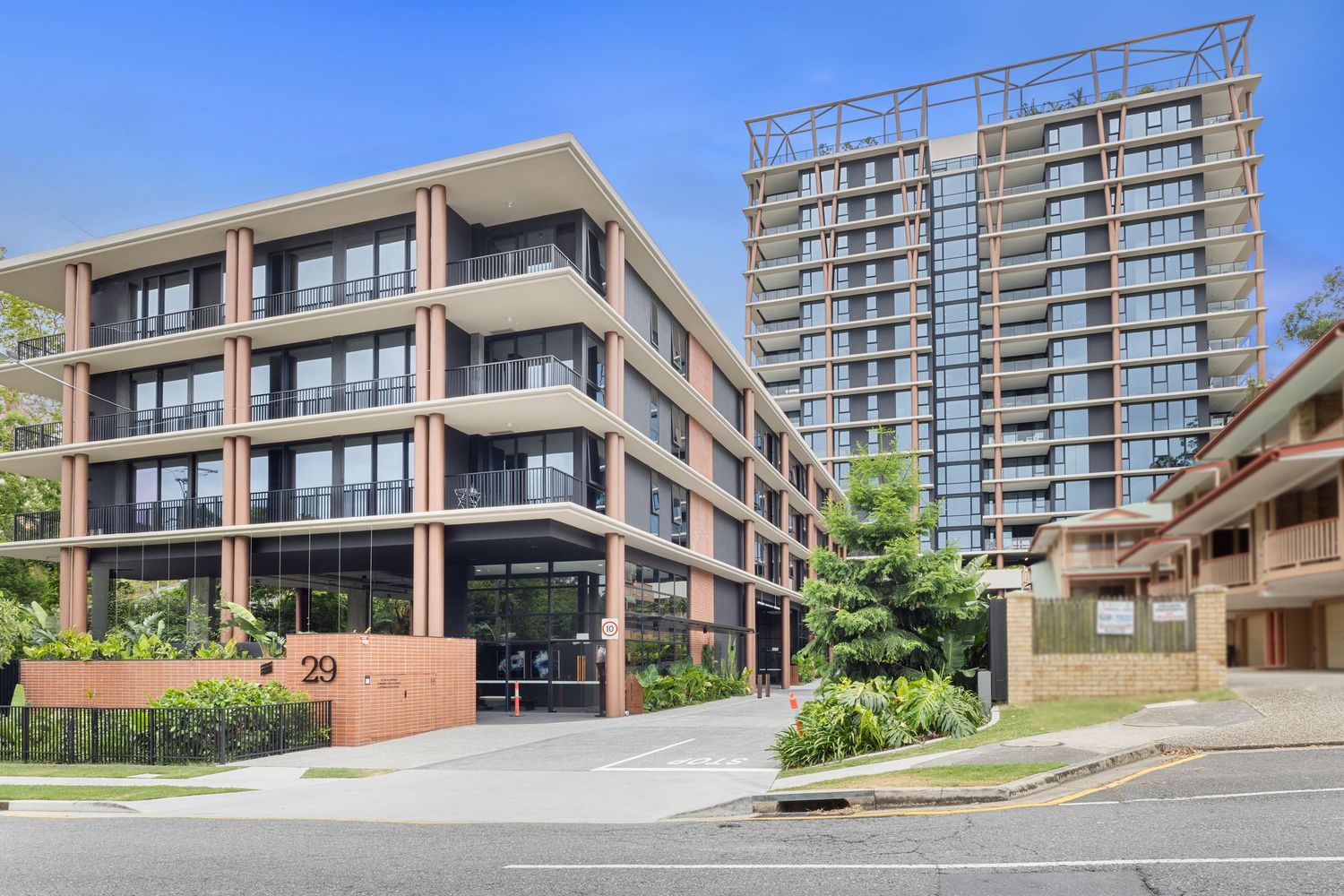 Row of modern townhouses with uniform design and landscaped frontage.