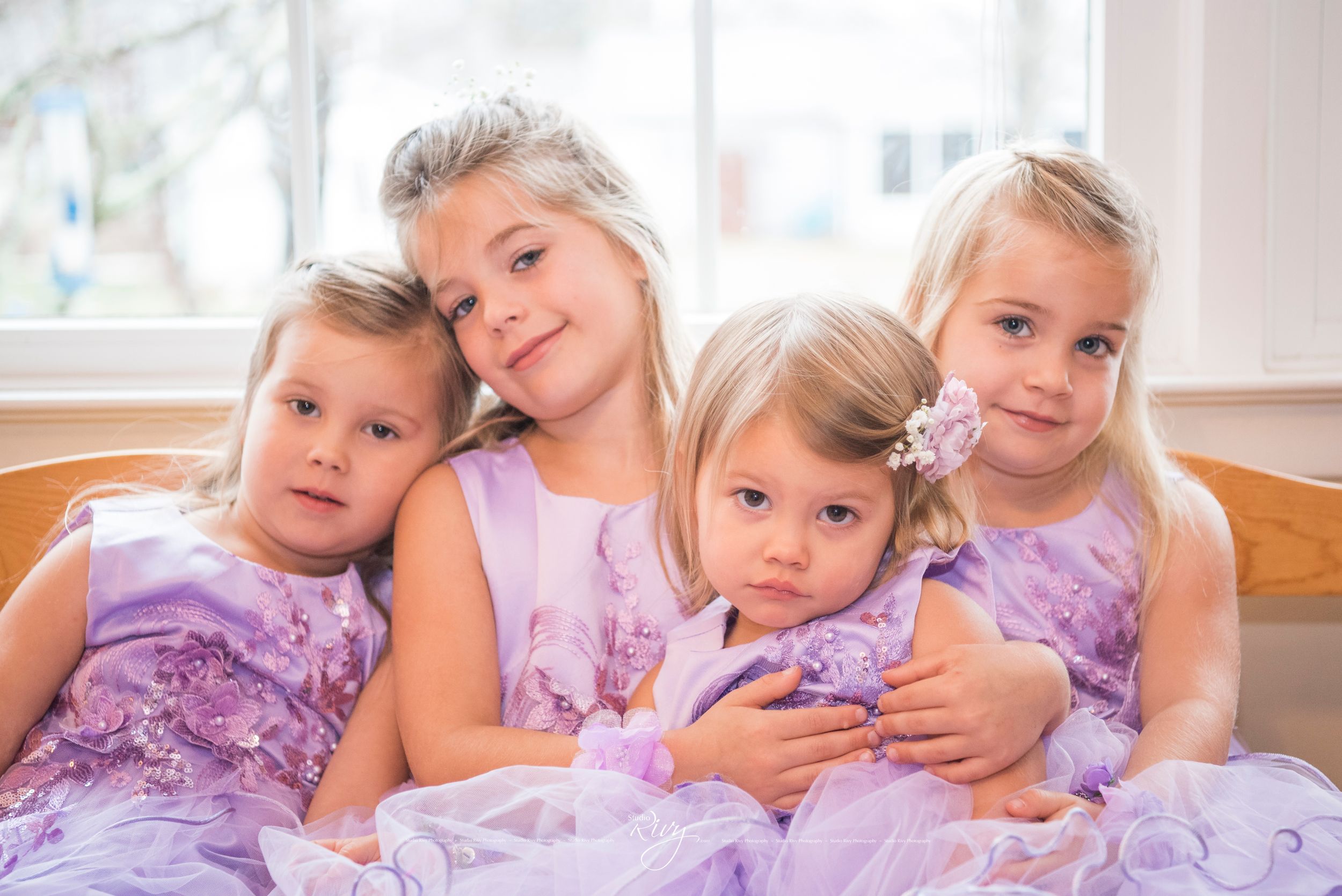 Cute sisters sit on couch together as they get ready for a wedding