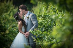 Bride and groom kiss in green garden