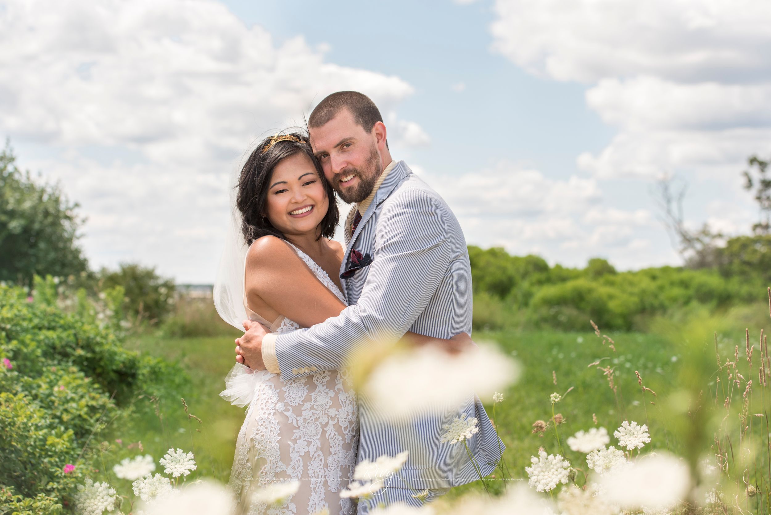Bride and groom embrace as they pose for a photo