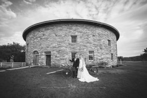 Bride and groom kiss in front of majestic, round structure