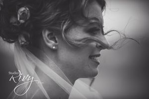 Bride thoughtfully looks into distance as wind majestically brushes her hair across her face