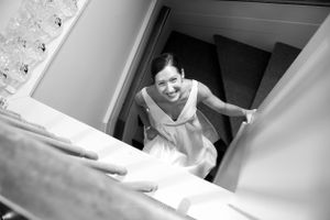 Pretty bride joyfully looks up a staircase in wedding dress at camera