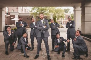 Groom and groomsmen pose for goofy photo under a bridge